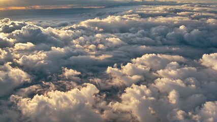 A video taken from above a dense layer of fluffy clouds at sunset. Websites or blogs can use this for themes of travel, freedom, spirituality, or weather.

