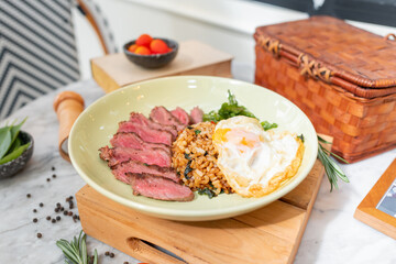 Gastronomic Delight: A delectable plate featuring a perfectly cooked steak, vibrant fried rice, and a sunny-side-up egg, artfully presented.