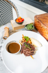 Gourmet Steak Dish: A top-down presentation of a culinary masterpiece, featuring a perfectly cooked steak, artfully arranged with side dishes and a rich sauce.