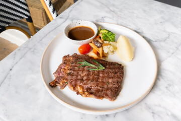 Gourmet Steak Plate: A mouthwatering culinary creation featuring a perfectly grilled steak, accompanied by an array of vibrant side dishes, all elegantly presented on a pristine plate. 