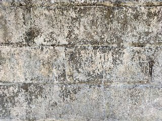 A detailed close-up of a textured concrete wall with visible horizontal lines. The surface is heavily weathered and stained with dark, grimy patches, creating a raw, industrial, and grunge-like feel.