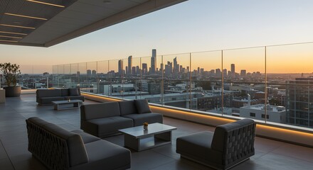 A modern rooftop terrace with comfortable lounge furniture overlooks a sprawling city skyline during a warm sunset.