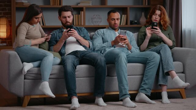 Group multiracial friends party at home using mobile phones gadget addict people on couch with smartphones chatting in social media ignoring each other multiethnic addicted women men overuse internet