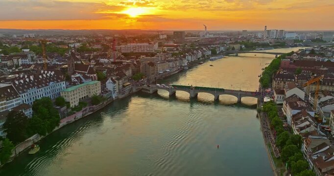 Aerial drone footage of the Basel old town along the Rhine river which contrast with modern skyscrapers in Switzerland. Shot with a forward and rotation motion. 
