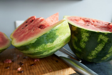 Watermelon slices on a cutting board with a knife on a table.