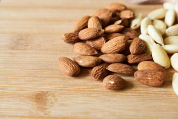 Almond nuts on wooden background. Healthy food concept. Peeled almonds. Copy space.