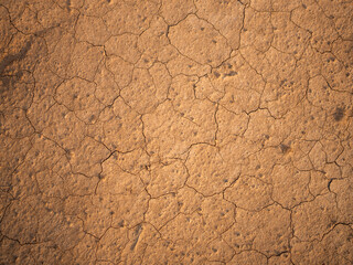 Close up of dried earth texture with clay and sand. Natural soil surface showing cracks, rough...