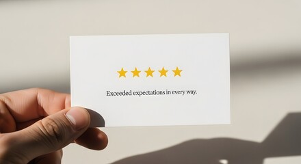 Hand holding a card with five golden stars and positive customer review text