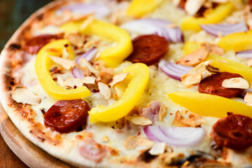 Pizza with chorizo ​​sausage, mozzarella cheese and yellow pepper. Rustic wooden background. Soft focus.	