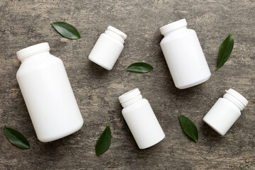 supplement pills with medicine bottle health care and medical top view. Vitamin tablets. Top view mockup bottle for pills and vitamins with green leaves, natural organic bio supplement, copy space