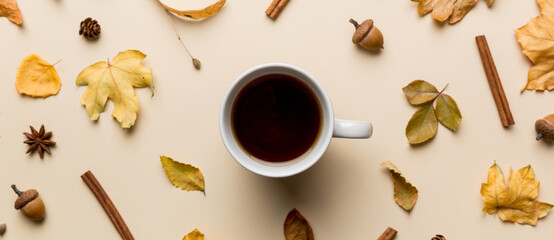Flat lay composition with colorful Autumn cup of coffee and leaves on a color background. top view