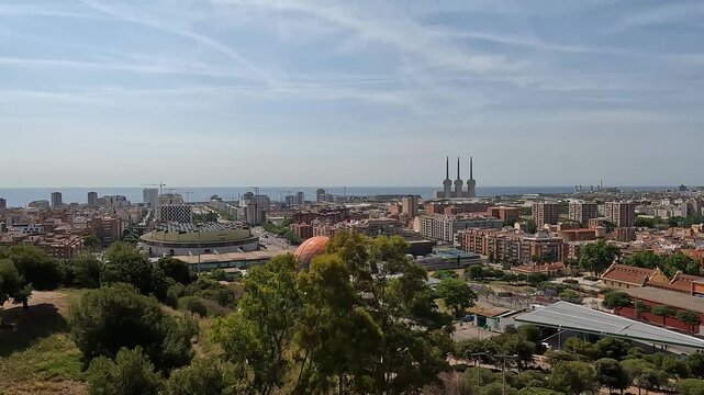 Badalona, Spain-23 August 2024. Panoramic view of the energy towers in Badalona, Spain, from a nature park. The harmony between nature and industry captured from a park overlooking three chimneys.
