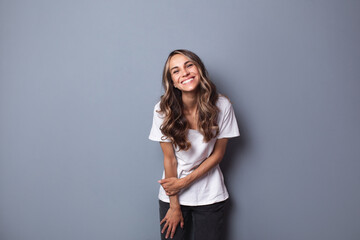 Young woman on gray background, confident positive girl.