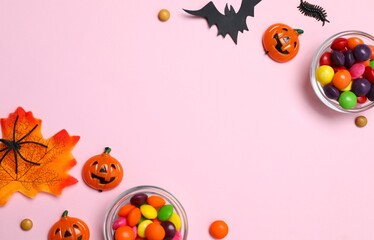 Halloween holiday concept. Festive background design with colorfull candies, bat, pumpkins and confetti. 