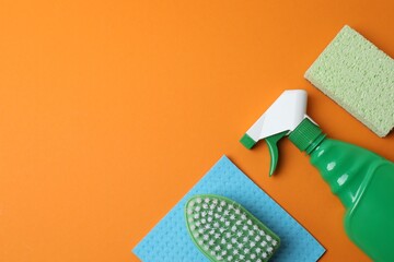 Flat lay with cleaning supplies including bottle, sponge, spray on pastel background. Top view