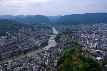 Phoenix Ancient Town, Hunan, China sprawls across green hills and a winding river, showing its...