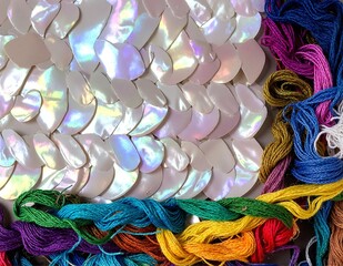 A vibrant assortment of multi-colored threads, featuring shades of red, blue, green, yellow, and purple, neatly arranged in a creative display.
