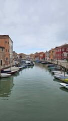 Scenic canal with colorful historic houses and boats in Murano island, Venice, Italy