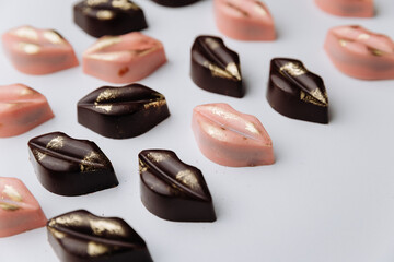 Luxury lip shaped chocolate candies with gold decor on pastel background