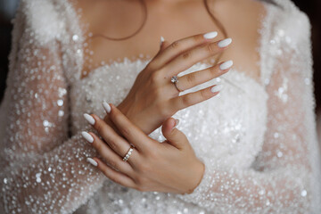 Bridal hands display elegant rings and manicured nails during wedding preparation