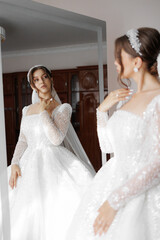 Fototapeta premium Bride admiring her elegant gown in a mirror before the wedding ceremony