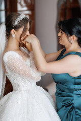 Bride prepares for wedding with mother's assistance in elegant setting