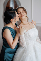 Bride and bridesmaid share a joyful moment before the wedding ceremony at a bridal suite