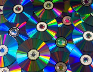 A vibrant array of colorful CDs is scattered haphazardly across a sleek black background, reflecting light and creating a dynamic visual contrast.