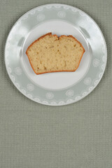 An overhead shot of a slice of bread on a decorative plate, set on a textured green placemat