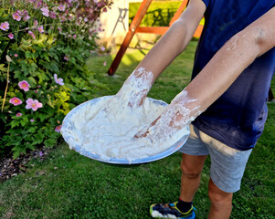 kids played chef at family cookout. son ended up stuck in a bowl of dough. both hands submerged in...