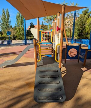 Escalera para subir a estructura con tobog&aacute;n en parque infantil cubierto con toldo de lona 
