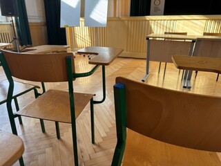desks attached to chairs in the auditorium of the college