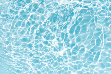 Blue water with ripples on the surface. Defocus blurred transparent blue colored clear calm water surface texture with splashes and bubbles. Water waves with shining pattern texture background.