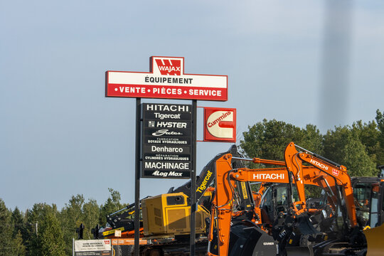 Canada, 09 August 2025 : Wajax heavy equipment dealership sign with Hitachi excavators and trees