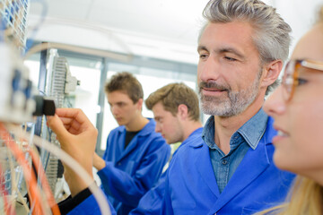 Obraz premium students and teacher with cables and wires