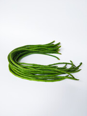 Fresh long green yardlong beans arranged on a white background