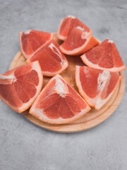 Fresh grapefruit wedges arranged on wooden plate, capturing the essence of citrus delight