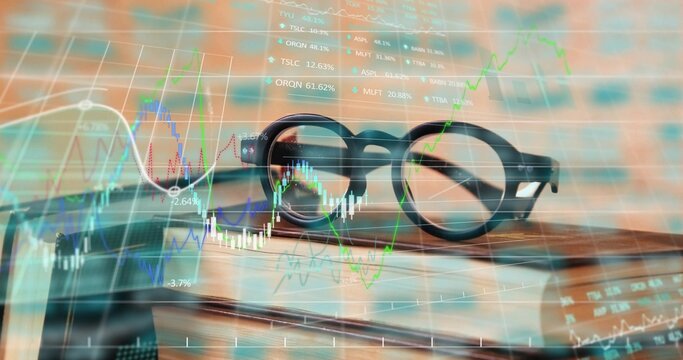 Displaying round-frame eyeglasses resting on books on desk in office, with stock chart overlays - Powered by Adobe