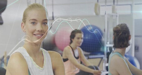 Smiling gym woman crossing arms on left side, with resistance machines and data overlay, copy space