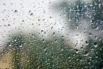 wet window background. rain drop on the glass surface. bad weather concept. urban landscape blurred in the distance