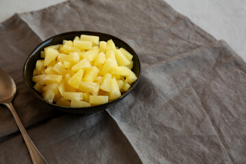 Canned Pineapple Tidbit Chunks in a Bowl, side view. Copy space.