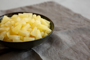 Canned Pineapple Tidbit Chunks in a Bowl, side view. Copy space.