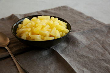 Canned Pineapple Tidbit Chunks in a Bowl, side view. Copy space.