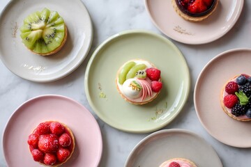 Overhead view of assorted small fruit tartlets on colorful plates, creating a vibrant and appetizing display