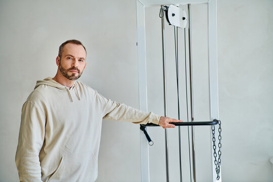 Man focused on rehabilitation exercises in a modern physical therapy center - Powered by Adobe