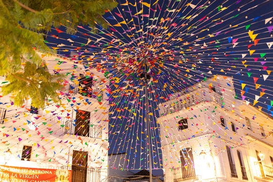 Fototapeta Colorful flags decorating Casares streets for village festival. Casares, Andalusia Spain. 5 September 2025.
