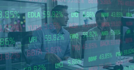 Coworkers wearing shirt and blouse discussing stock data on laptop with tickers in open office