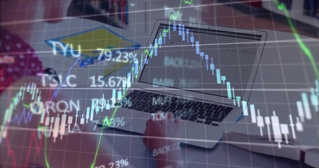 Typing teenager using laptop in home office, with smartphone notebook pen and chart overlays