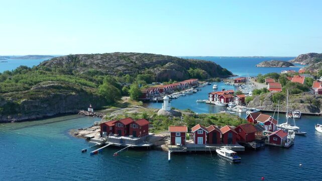 Idyllic red fisherman cabins in Sweden. Typical Swedish wooden house constructions fishing sheds on Island in aerial drone view. Expensive small barns ocean front. Bohus Malm&ouml;n