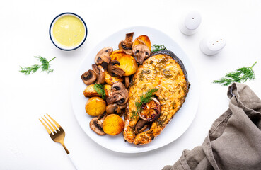Yummy dinner with grilled salmon, baby potatoes and mushrooms with creamy garlic sauce on white table, top view